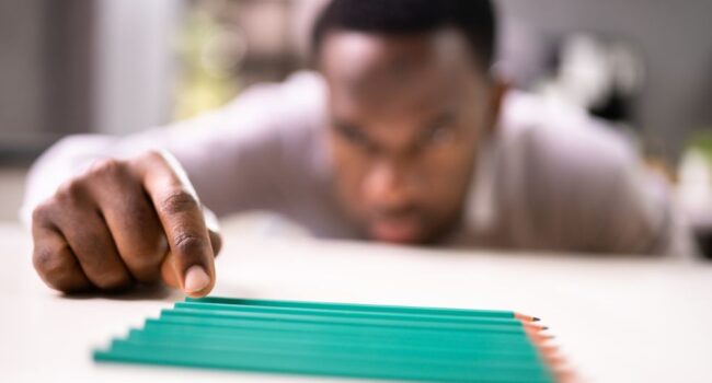 man tidying pencils showing signs of OCD